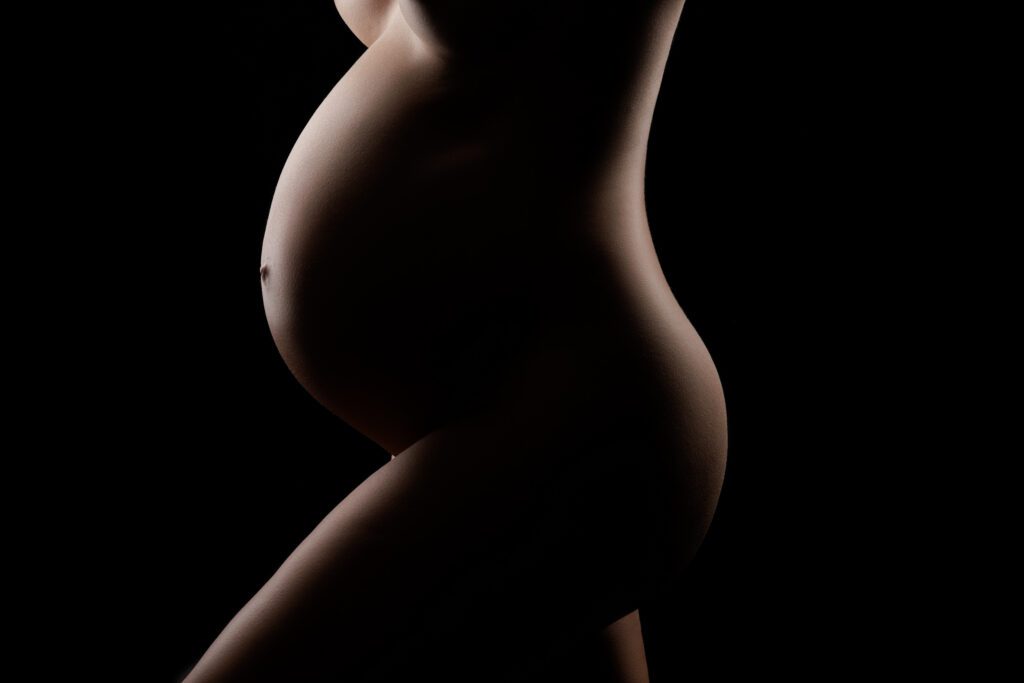 Nude silhouette of pregnant belly