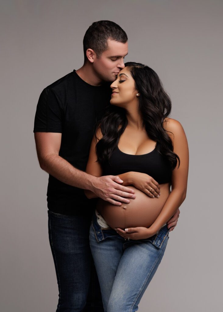 pregnant couple posing wearing casual matching outfits