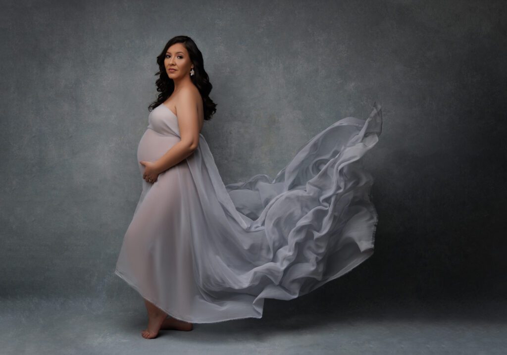 maternity photograph of woman wearing flown grey silk