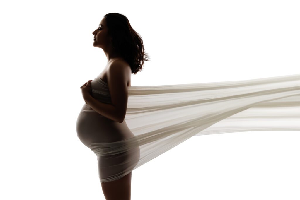 side profile of woman and belly bump with fabric around it