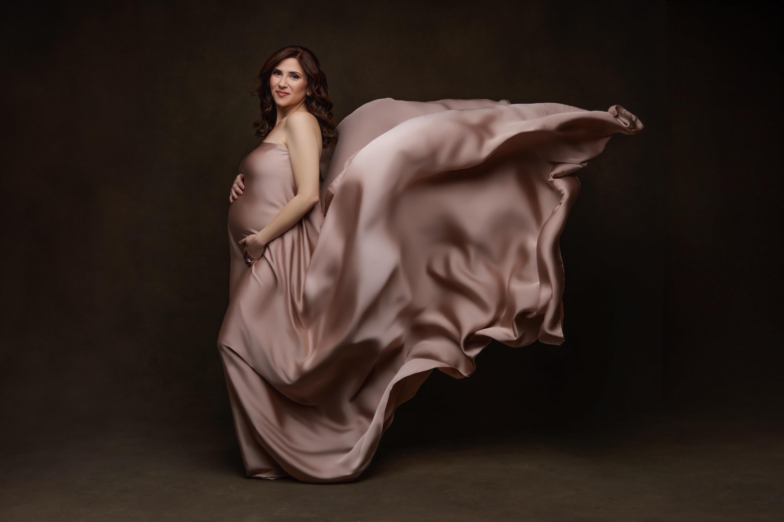 pregnant woman with pink silk drapped over