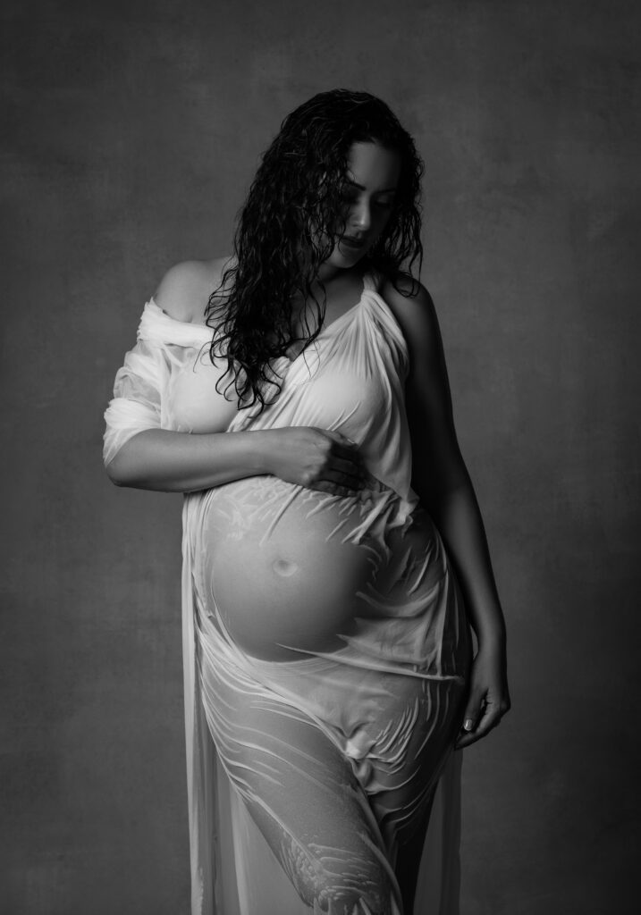 black and white maternity shoot of woman in wet sheet